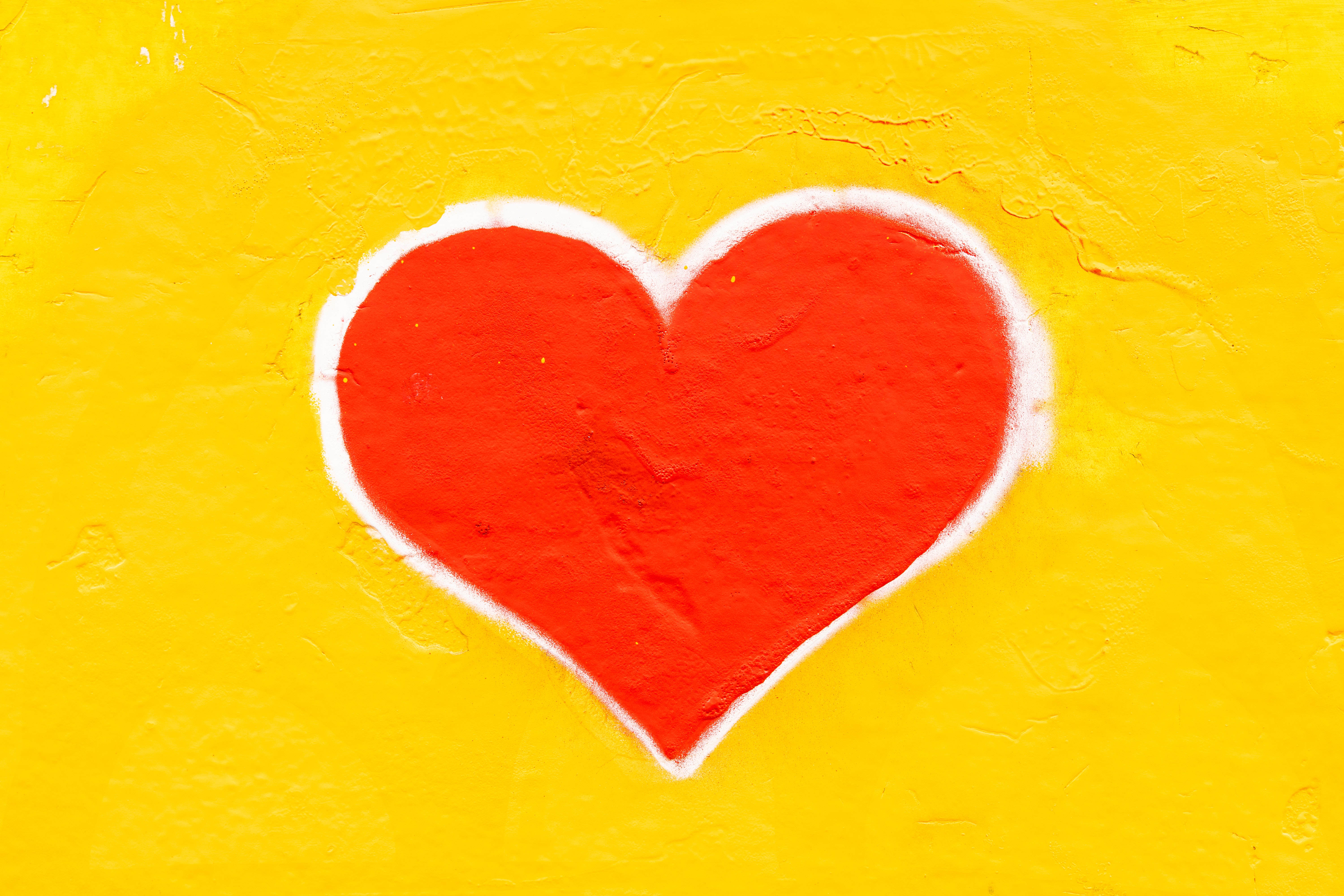 Corazón pintado en la pared amarilla